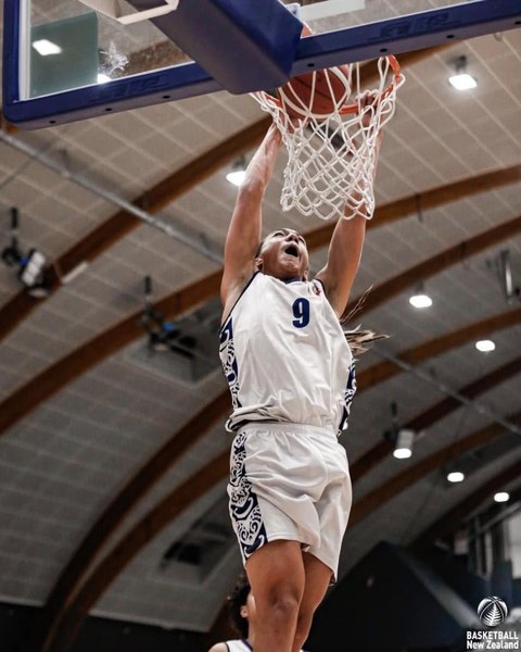 A player in a white number 9 uniform dunks the ball.
