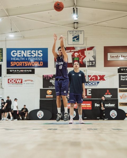A Poitūkohu Māori player in number 8 takes a jump shot during warm-ups in Cairns while a teammate watches.