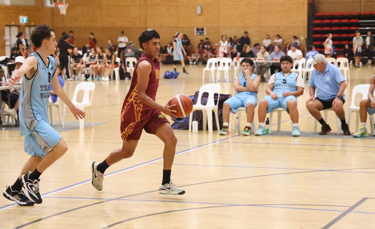 Rotorua player advances with the ball alongside a defender.