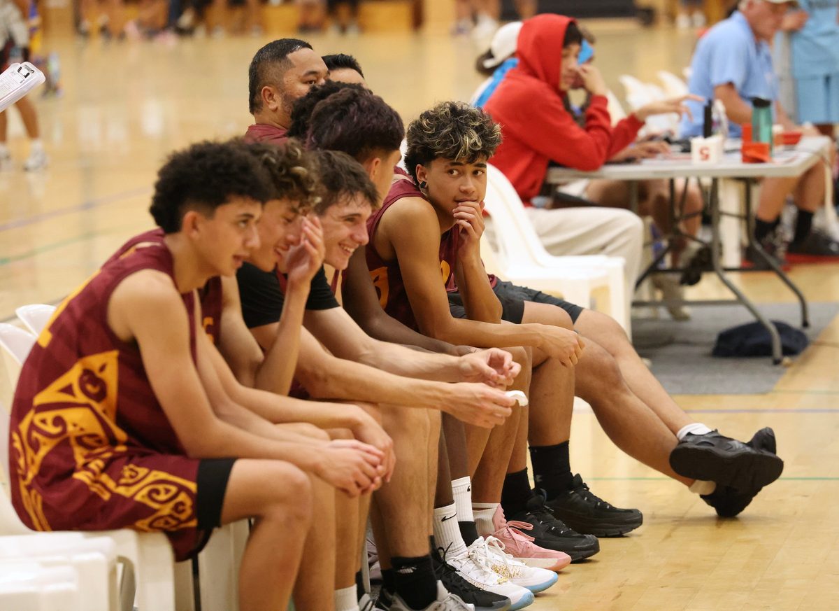 Rotorua teammates sit together watching the game.