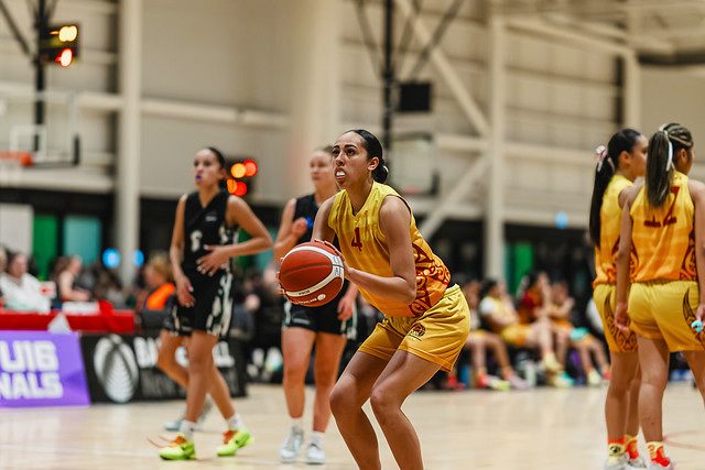 Rotorua number 4 holds the ball and looks towards the basket.