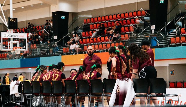 Rotorua players listen to their coach during a timeout at the bench.