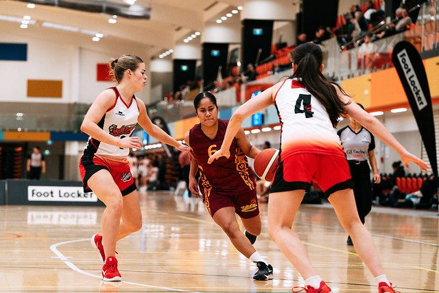 Rotorua number 6 carries the dribble between two defenders.