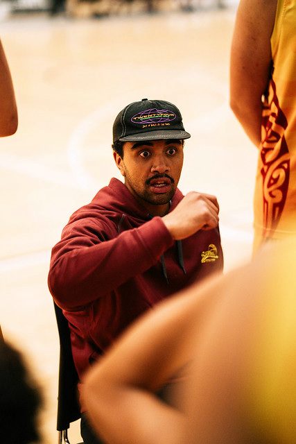 A Rotorua coach gives instructions to players gathered close around him.