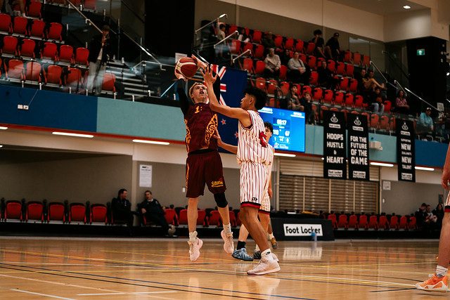Rotorua player rises for a jump shot as a defender contests it.